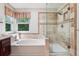 Bathroom featuring separate shower and soaking tub, with beige stone tile work at 775 Poppywood Dr, Highlands Ranch, CO 80126