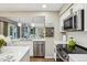 Kitchen features stainless steel appliances, white cabinetry, and an open layout at 775 Poppywood Dr, Highlands Ranch, CO 80126