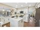 Bright and airy kitchen with island, white cabinetry, stainless appliances, and hardwood floors at 775 Poppywood Dr, Highlands Ranch, CO 80126