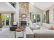 Spacious living room with stone fireplace, vaulted ceilings, and patio access provides a comfortable gathering space at 775 Poppywood Dr, Highlands Ranch, CO 80126