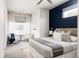 Comfortable bedroom with a plush bed, accent wall, and seating area near the bright sunny window at 3145 W 19Th Ave, Denver, CO 80204
