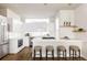 Contemporary kitchen featuring sleek white cabinetry, stainless steel appliances, and a convenient breakfast bar at 3145 W 19Th Ave, Denver, CO 80204
