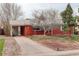 Traditional single-story red brick home featuring mature trees and a covered car port at 2885 S Gilpin St, Denver, CO 80210