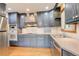 Well-equipped kitchen featuring stainless steel appliances, light countertops, and blue cabinetry at 2885 S Gilpin St, Denver, CO 80210