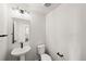 Stylish half bathroom featuring modern fixtures, a pedestal sink, and neutral decor at 8777 Whiteclover St, Littleton, CO 80125
