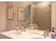 Bathroom features a double vanity, large mirror, neutral paint, and shower with tile surround at 10018 E 62Nd Ave, Denver, CO 80238