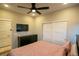Bedroom features a ceiling fan, mounted television, closet and neutral paint at 10018 E 62Nd Ave, Denver, CO 80238