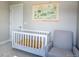 Cozy Bedroom features a crib, glider, soft paint, and custom map art at 10018 E 62Nd Ave, Denver, CO 80238