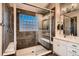 Elegant bathroom featuring a tiled shower with a glass enclosure and a vanity with marble countertops at 13076 Marion Dr, Thornton, CO 80241