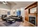 Cozy living room featuring a fireplace, built-in shelving, large windows, and comfortable seating at 13076 Marion Dr, Thornton, CO 80241