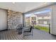View from the balcony with wood decking, brick accent wall, and seating, overlooking the backyard at 6400 Barnstead Dr, Castle Pines, CO 80108