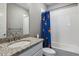 Bathroom featuring granite countertop vanity and a bathtub with colorful shower curtain at 6400 Barnstead Dr, Castle Pines, CO 80108