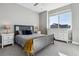 Bedroom with light grey walls and carpet, a large window and dresser at 6400 Barnstead Dr, Castle Pines, CO 80108