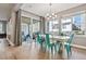Dining room with large windows, light wood floors, modern chandelier, and access to the outdoor patio at 6400 Barnstead Dr, Castle Pines, CO 80108