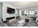 Comfortable living room with modern fireplace, TV, large windows, and cozy seating, perfect for relaxation at 6400 Barnstead Dr, Castle Pines, CO 80108