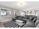 Large living room with big windows, neutral walls, modern decor, and an open view to the kitchen at 6400 Barnstead Dr, Castle Pines, CO 80108