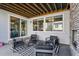 Covered patio with stone fireplace, four chairs, a table and a black and white striped rug at 6400 Barnstead Dr, Castle Pines, CO 80108