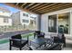 Covered patio with four chairs, a table and a black and white striped rug, overlooking the yard at 6400 Barnstead Dr, Castle Pines, CO 80108