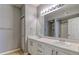 Bright bathroom with double sinks, white cabinets, and large mirror at 7440 S Blackhawk St # 12-204, Englewood, CO 80112