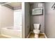 Bathroom with a shower over tub and white subway tile surround, toilet, and cabinet at 7440 S Blackhawk St # 12-204, Englewood, CO 80112