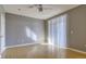 Empty bedroom featuring wood-look floors, gray walls, a ceiling fan, and bright light from a large window at 7440 S Blackhawk St # 12-204, Englewood, CO 80112