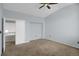 Carpeted bedroom with a ceiling fan, neutral paint, an ensuite bathroom, and a closet at 162 Blue Spruce Ct, Highlands Ranch, CO 80126