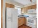 View of the kitchen features wood cabinets, a white refrigerator, a white stove, and dark countertops at 162 Blue Spruce Ct, Highlands Ranch, CO 80126