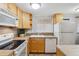 Bright kitchen featuring a microwave, stove, refrigerator, and a window with blinds at 1260 N Humboldt St # 1, Denver, CO 80218