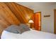 Bedroom featuring a wooden accent wall, a bedside table and an open door to the bathroom at 305 S Park Ave # 205, Breckenridge, CO 80424