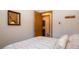 Bedroom with a view to an en suite bathroom, a comfortable bed and wood accent wall at 305 S Park Ave # 205, Breckenridge, CO 80424