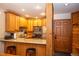 Well-lit kitchen features warm wood cabinetry, modern appliances, and a breakfast bar with stool seating at 305 S Park Ave # 205, Breckenridge, CO 80424