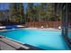 Community swimming pool with chairs, tables and privacy fence with mature pine trees in the background at 305 S Park Ave # 205, Breckenridge, CO 80424