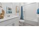 Bright bathroom with a combined tub and shower, white vanity, and tasteful decorative artwork at 4708 Windmill Dr, Brighton, CO 80601