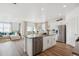 Modern kitchen with stainless steel appliances, a center island, and open views into the living room and dining area at 4708 Windmill Dr, Brighton, CO 80601