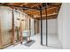 Unfinished basement featuring an open ceiling, white floors, and a laundry sink at 14121 E Baltic Pl, Aurora, CO 80014