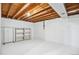 Unfinished basement featuring an open ceiling, white floors, and storage space at 14121 E Baltic Pl, Aurora, CO 80014
