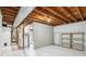 Unfinished basement featuring open ceiling with laundry area, storage, and a door leading to a bathroom at 14121 E Baltic Pl, Aurora, CO 80014