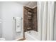 Bathroom with shower featuring white curtain and brown tiles. Includes white towel racks at 14121 E Baltic Pl, Aurora, CO 80014