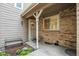 Inviting front door with decorative wreath and charming covered porch, adjacent to a small bench and landscaped garden at 14121 E Baltic Pl, Aurora, CO 80014