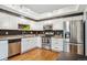 Well-lit kitchen with stainless steel appliances, white cabinets and wood flooring at 14121 E Baltic Pl, Aurora, CO 80014