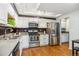 Bright kitchen with stainless steel appliances, white cabinets and dark backsplash at 14121 E Baltic Pl, Aurora, CO 80014