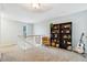 A cozy loft area with carpet flooring, bookshelves and a comfortable chair and guitar at 14121 E Baltic Pl, Aurora, CO 80014