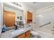 Bathroom with granite countertop, wood cabinets and a shower over tub with grab bars at 2517 E Egbert St, Brighton, CO 80601