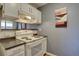 A functional kitchen includes a white stove oven, white cabinetry, and dark counter tops at 1105 Bacchus Dr # F8, Lafayette, CO 80026