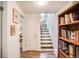 Hallway with wooden floors, a staircase, and access to a room with a white door, bookshelf and framed art at 1842 Canyon Blvd # 105, Boulder, CO 80302