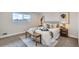 Cozy bedroom with neutral tones, a comfortable bed, a decorative bench, and ample natural light at 12932 E Elgin Pl, Denver, CO 80239