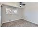 Well-lit bedroom with a ceiling fan and a large window overlooking the outdoors at 12932 E Elgin Pl, Denver, CO 80239