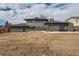 Rear exterior view of a home with a patio, brick accents, and neutral-toned siding at 12932 E Elgin Pl, Denver, CO 80239