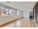 Bright living room with wood-look flooring, large windows, and access to a stairway and a distinctive accent wall at 12932 E Elgin Pl, Denver, CO 80239