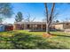 Backyard with a covered patio, well-maintained lawn, shed, and mature trees, providing a private outdoor oasis at 3395 W Union Ave, Englewood, CO 80110